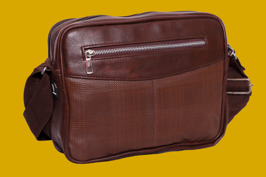 Brown leatherette bag with a visible zipper on a mustard background