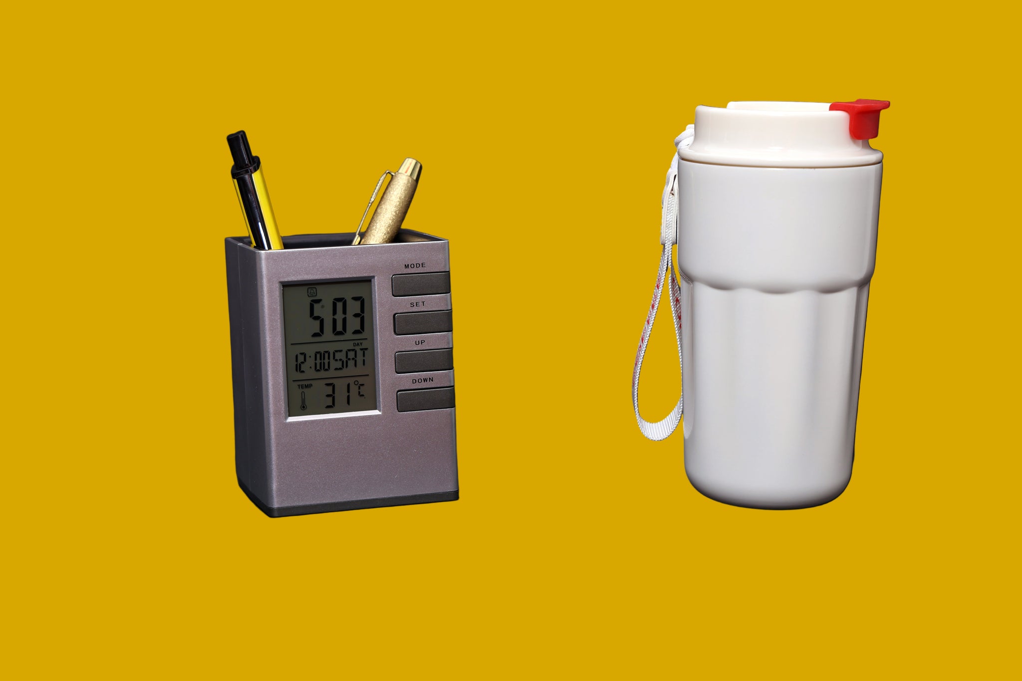 Digital clock with pen holder and white water bottle on a mustard background