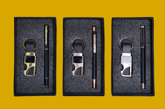 Three sets of keychains and pens in black boxes.