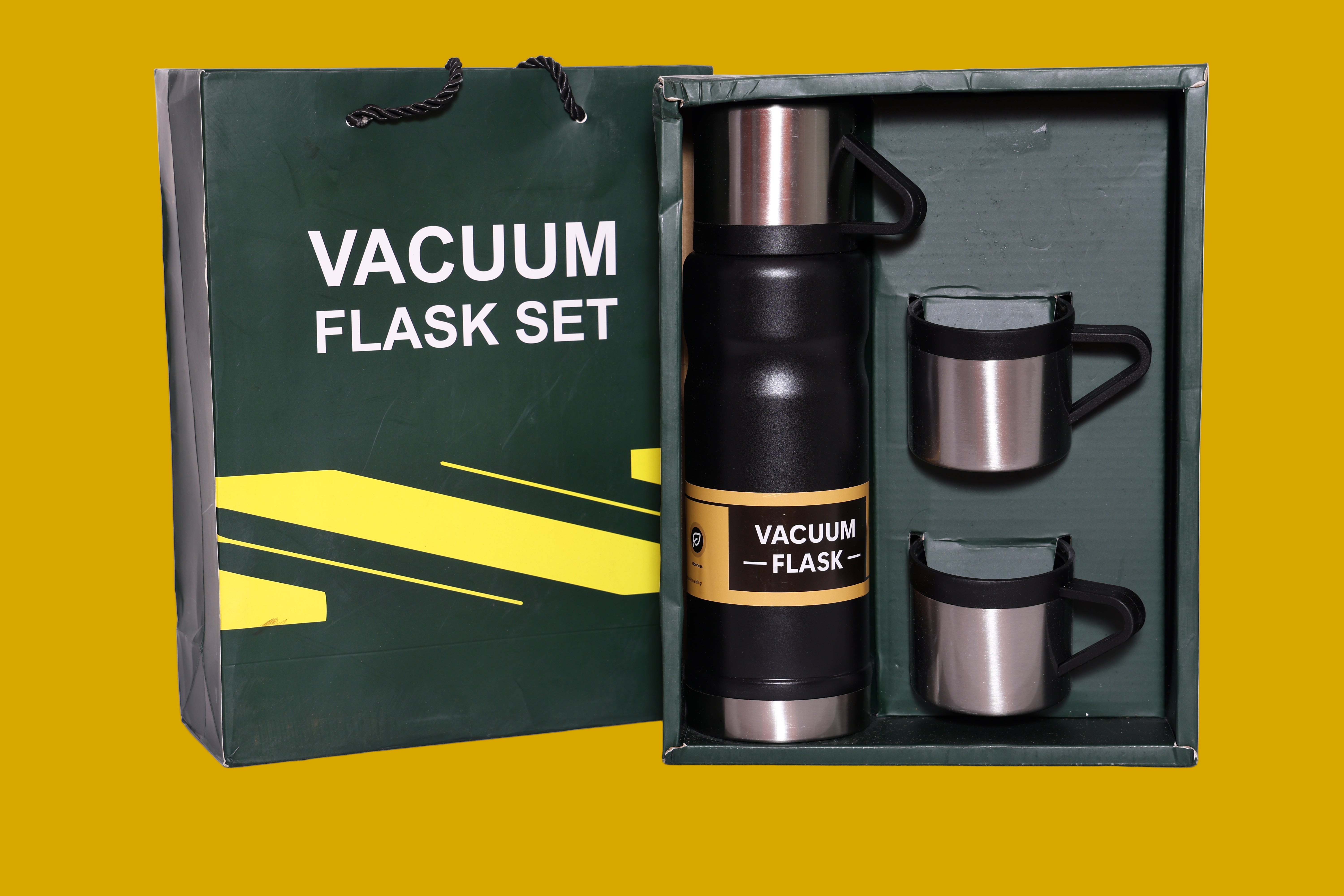 Vacuum flask set with two mugs and a branded bag on a mustard background
