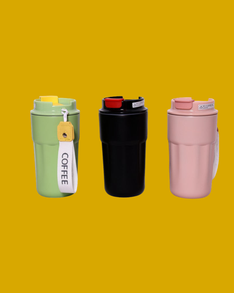 Three reusable mini coffee flasks in green, black, and pink on a mustard background